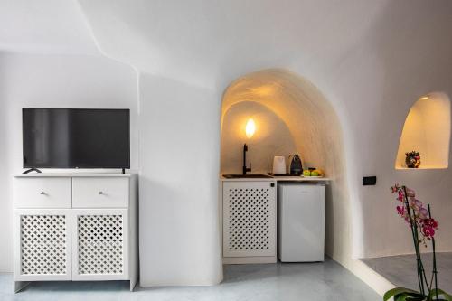 a living room with a television on a white cabinet at Ecolodge Cave House in Vóthon