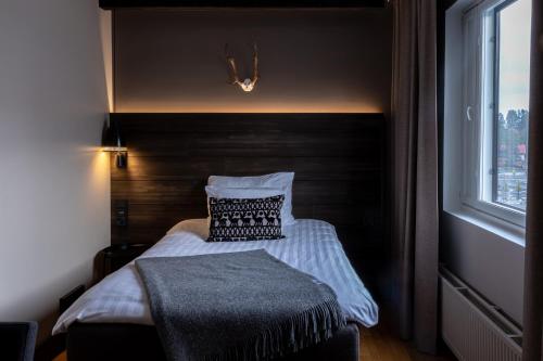 a bedroom with a bed with a pillow and a window at Lapland Hotels Kuopio in Kuopio