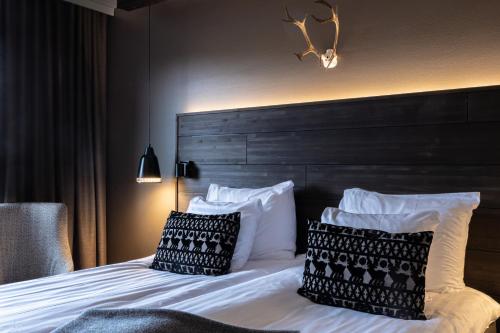 a bedroom with a bed with two pillows on it at Lapland Hotels Kuopio in Kuopio