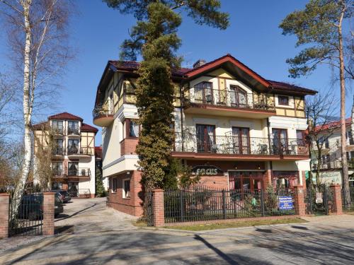 an apartment building with a tree in front of it at Willa Focus in Mielno