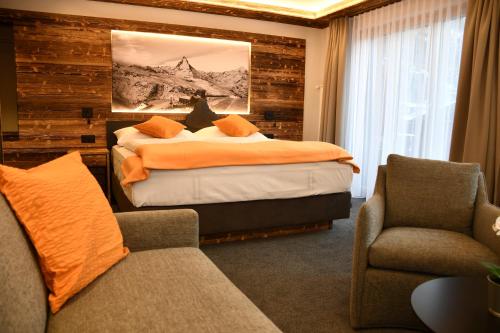 a bedroom with a bed and a couch and a chair at Elite in Zermatt