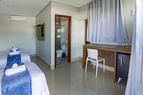 a hotel room with two beds and a bathroom at Villa Tereza in Alto Paraíso de Goiás