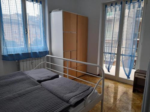 sypialnia z łóżkiem, lodówką i oknami w obiekcie Casa del mare Ligure Borgio Verezzi w mieście Borgio Verezzi