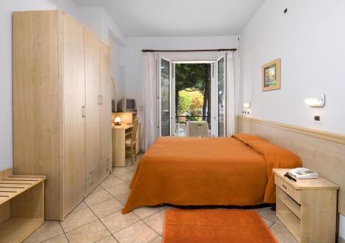 Schlafzimmer mit einem Bett, einem Schreibtisch und einem Fenster in der Unterkunft Hotel Walter in Gatteo a Mare