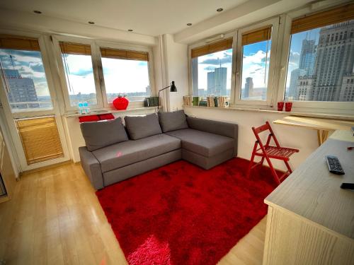 ein Wohnzimmer mit einem Sofa und einem roten Teppich in der Unterkunft Super Apartament RED Centrum Best View in Town 2x Metro Fast WiFi 300 Mbs Netflix AppleTV SmartTV Spotify Panorama Miasta in Warschau