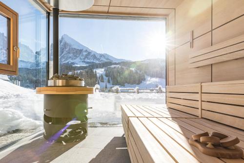 a room with a large window with a view of a mountain at Brunelle Seiser Alm Lodge in Alpe di Siusi