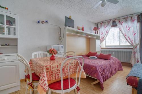1 dormitorio con 1 cama, mesa y sillas en Les Cimes de Belle Hutte, en La Bresse