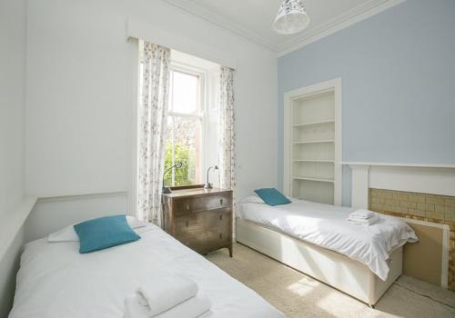 a bedroom with two beds and a sink and a window at Linda Vista in North Berwick