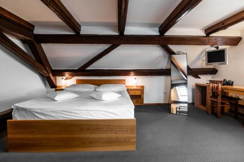 a bedroom with a bed and a desk and a television at Hotel Dvor Jezersek Brnik in Cerklje na Gorenjskem