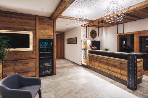 una sala de degustación con paredes de madera, TV y silla en Alpenheimat Laurschhof, en Fiss