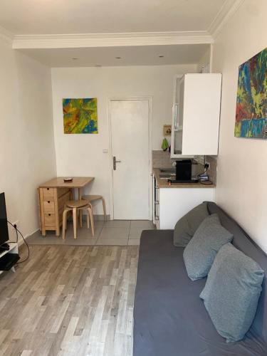 un salon avec un canapé et une cuisine dans l'établissement Cosy, charming apartment with courtyard, à Paris