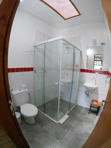 a bathroom with a shower and a toilet and a sink at Recanto das Carpas in Ilhabela
