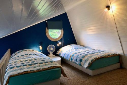 聖皮耶爾基貝隆的住宿－Maisonnette atypique des années 1960，一间卧室设有两张单人床和一个窗户。