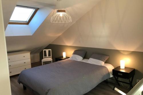 een slaapkamer met een bed met 2 nachtkastjes en 2 verlichting bij Magnifique duplex super cosy Vue mer 180 in Ploemeur
