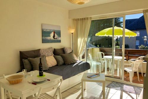 uma sala de estar com um sofá e uma mesa em Studio cabine Méga cosy Bord de mer - Terrasse em Quiberon