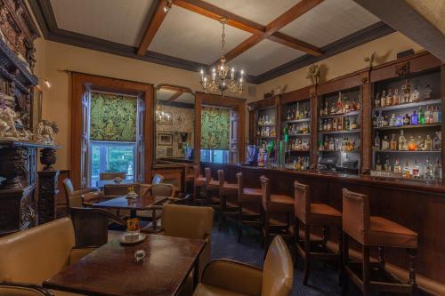 a restaurant with tables and chairs and a bar at Ballyseede Castle in Tralee