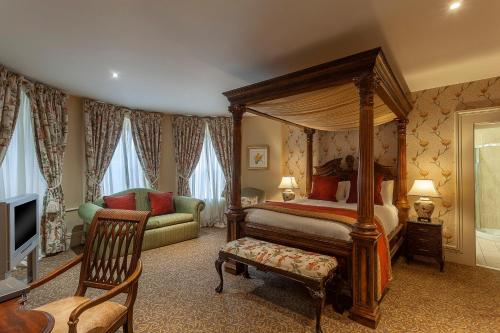 a bedroom with a canopy bed and a couch at Ballyseede Castle in Tralee