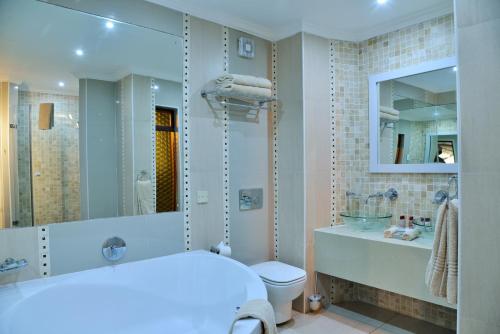 ein Badezimmer mit einer Badewanne, einem WC und einem Waschbecken in der Unterkunft Cresta Mowana Safari Resort & Spa in Kasane