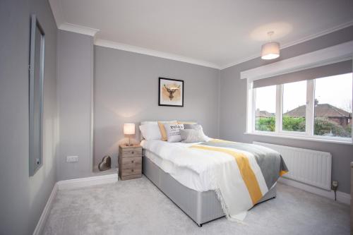een witte slaapkamer met een bed en een raam bij Keithlands House By Horizon Stays in Stockton-on-Tees