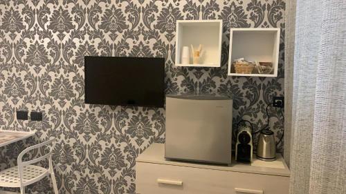 a television sitting on a desk in a room with wallpaper at Flaminio Holidays in Rome