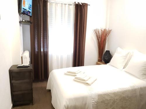 a bedroom with a white bed and a window at Les Pieds dans l'Eau in Nice