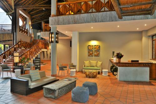 a living room with a couch and chairs and stairs at Cresta Mowana Safari Resort & Spa in Kasane