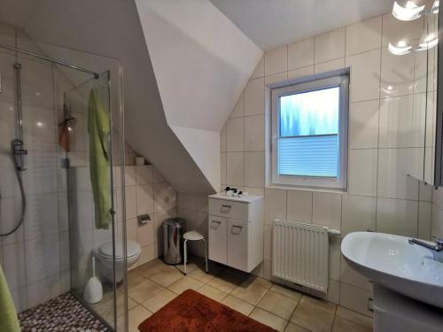 een badkamer met een douche, een toilet en een wastafel bij Ferienhaus Tönsing in Horumersiel