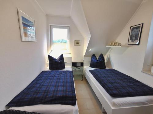 two beds in a room with blue pillows at Ferienhaus Tönsing in Horumersiel