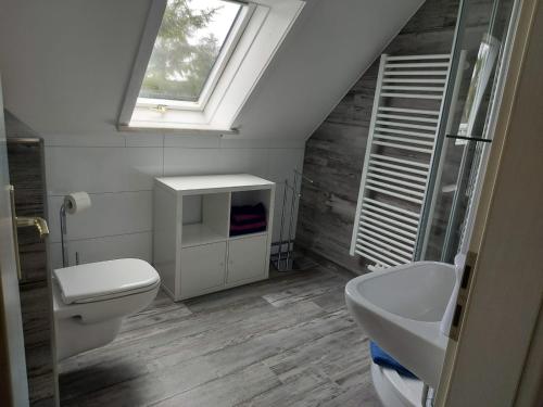 uma casa de banho com um WC, um lavatório e uma janela em Ferienwohnung Grunwald em Oberhof