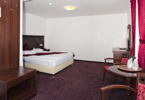 a hotel room with a bed and a table at Hanul Domnesc in Braşov