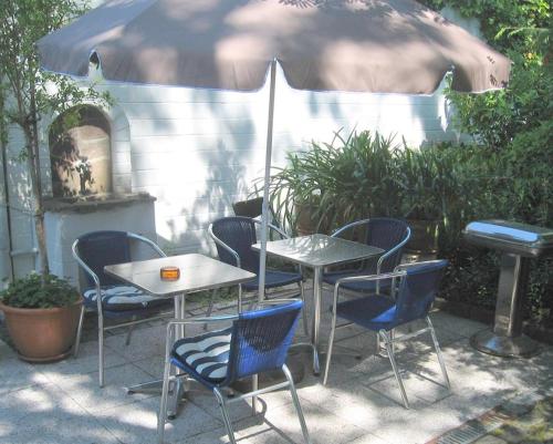 una mesa, sillas y una sombrilla en el patio en Altes Schulhaus, en Bad Schwartau