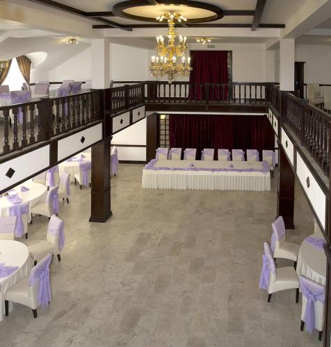 a banquet hall with white tables and chairs and a chandelier at Hanul Domnesc in Braşov