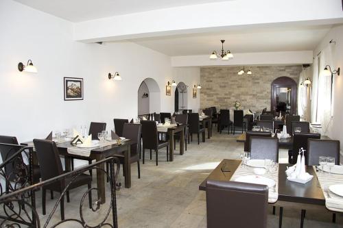 a dining room with tables and black chairs at Hanul Domnesc in Braşov