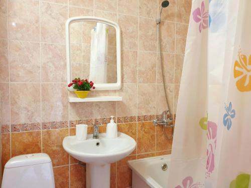 bagno con lavandino, specchio e servizi igienici di Уютная Однушка a Atyraū