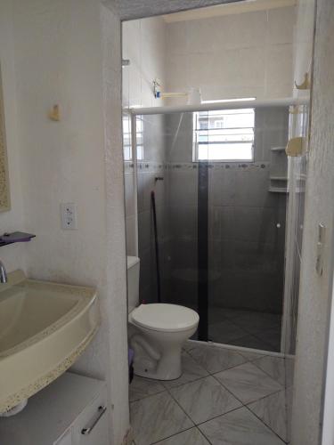 ein Badezimmer mit Dusche, Toilette und Waschbecken in der Unterkunft Casa grande e confortável em Ilha Comprida in Ilha Comprida