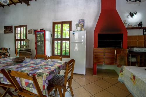 a kitchen with a table and a white refrigerator at Sítio Martins com lazer completo em Ibiúna, SP in Ibiúna