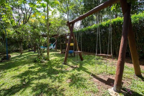 a swing set in a park with trees at Sítio Martins com lazer completo em Ibiúna, SP in Ibiúna