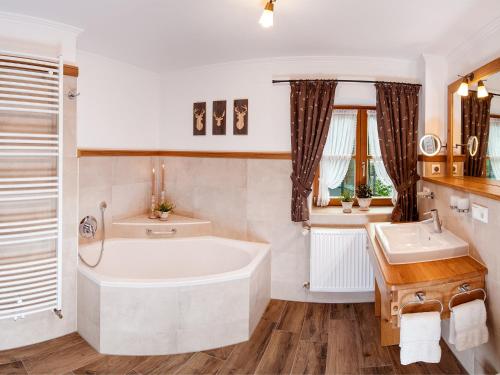 a bathroom with a tub and a sink at Ferienwohnungen Mayer inkl. Chiemgaukarte in Ruhpolding