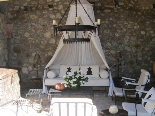 a porch with a bed with a chandelier at Can Serola in Sales del Llierca