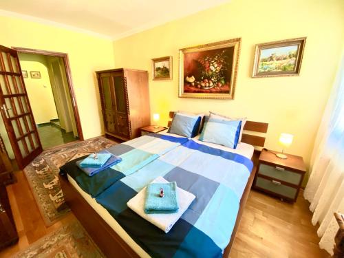 a bedroom with a bed with blue towels on it at Zalár Apartman in Eger