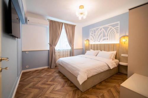 - une chambre avec un grand lit et une fenêtre dans l'établissement History Museum Apartment, à Bucarest