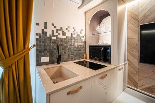 een keuken met een spoelbak en een magnetron bij History Museum Apartment in Boekarest