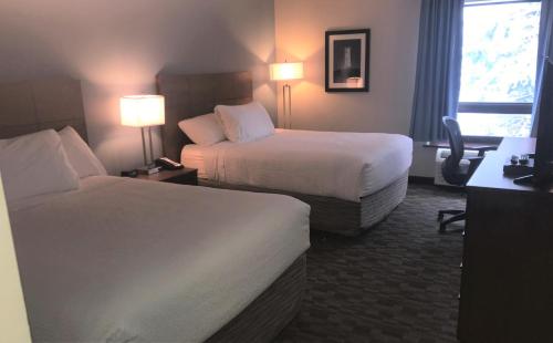 
a hotel room with two beds and two lamps at Travelodge by Wyndham Sydney in Sydney
