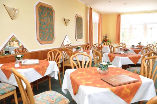 a restaurant with tables and chairs in a room at Pension Müritzblick in Waren