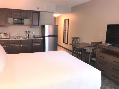 a small kitchen with a refrigerator and a table at Travelodge by Wyndham Sydney in Sydney