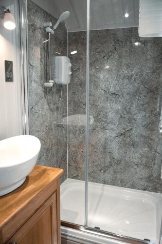 a bathroom with a shower and a sink at Dawn Chorus Holidays in Beccles