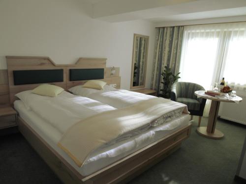 WeerbergにあるHotel Garni Reginaのベッドルーム(大型ベッド1台、テーブル付)