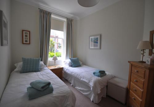 1 dormitorio con 2 camas y ventana en Links Corner en Gullane