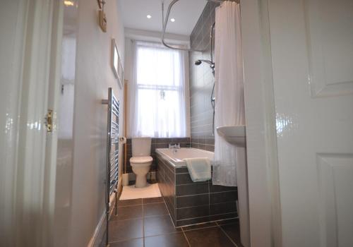 uma casa de banho com uma banheira, um lavatório e um WC. em Links Corner em Gullane