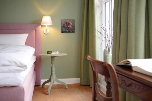 a bedroom with a bed and a table next to a window at Hotel No. 11 in Lüdinghausen